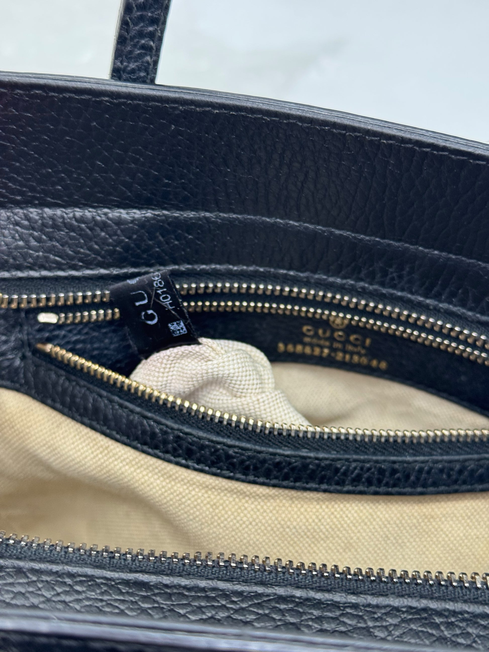 Interno di una borsa a mano Borse Vintage Gucci in pelle nera con etichetta del logo e codice seriale dorato