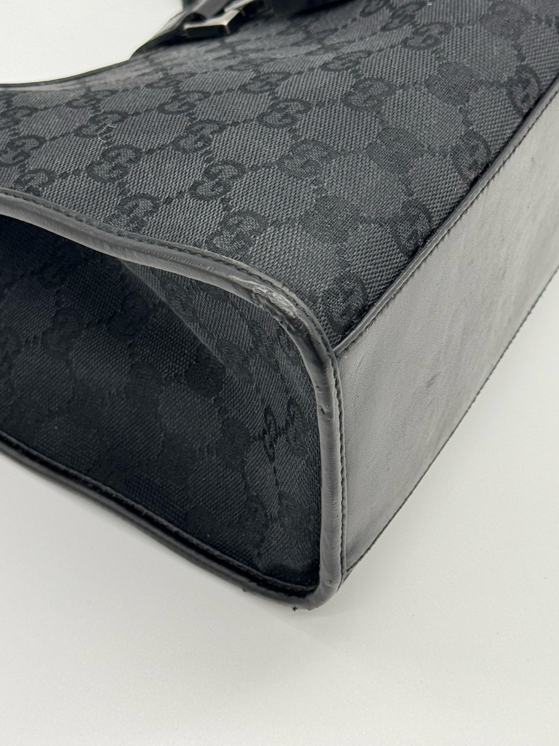 Dettaglio laterale della borsa a spalla Borse Vintage Gucci Jackie in tessuto nero con motivo GG e finiture in pelle