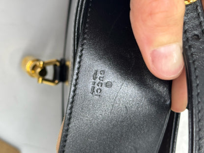 Dettaglio del logo Gucci impresso su pelle nera liscia della borsa a spalla Jackie 1961 di Borse Vintage