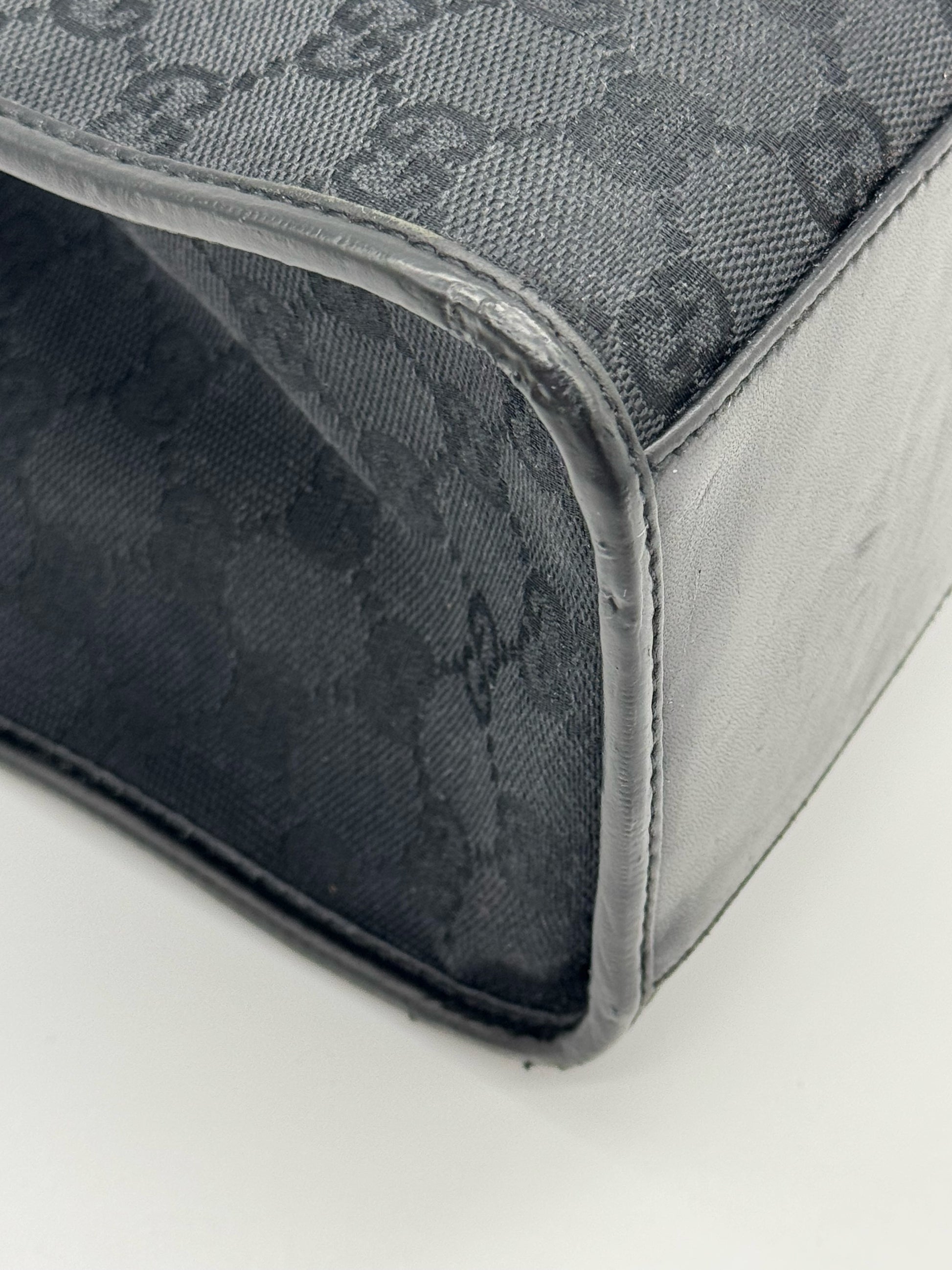 Dettaglio dell'angolo di una borsa Borse Vintage Gucci Jackie in tessuto nero con motivo GG e finiture in pelle