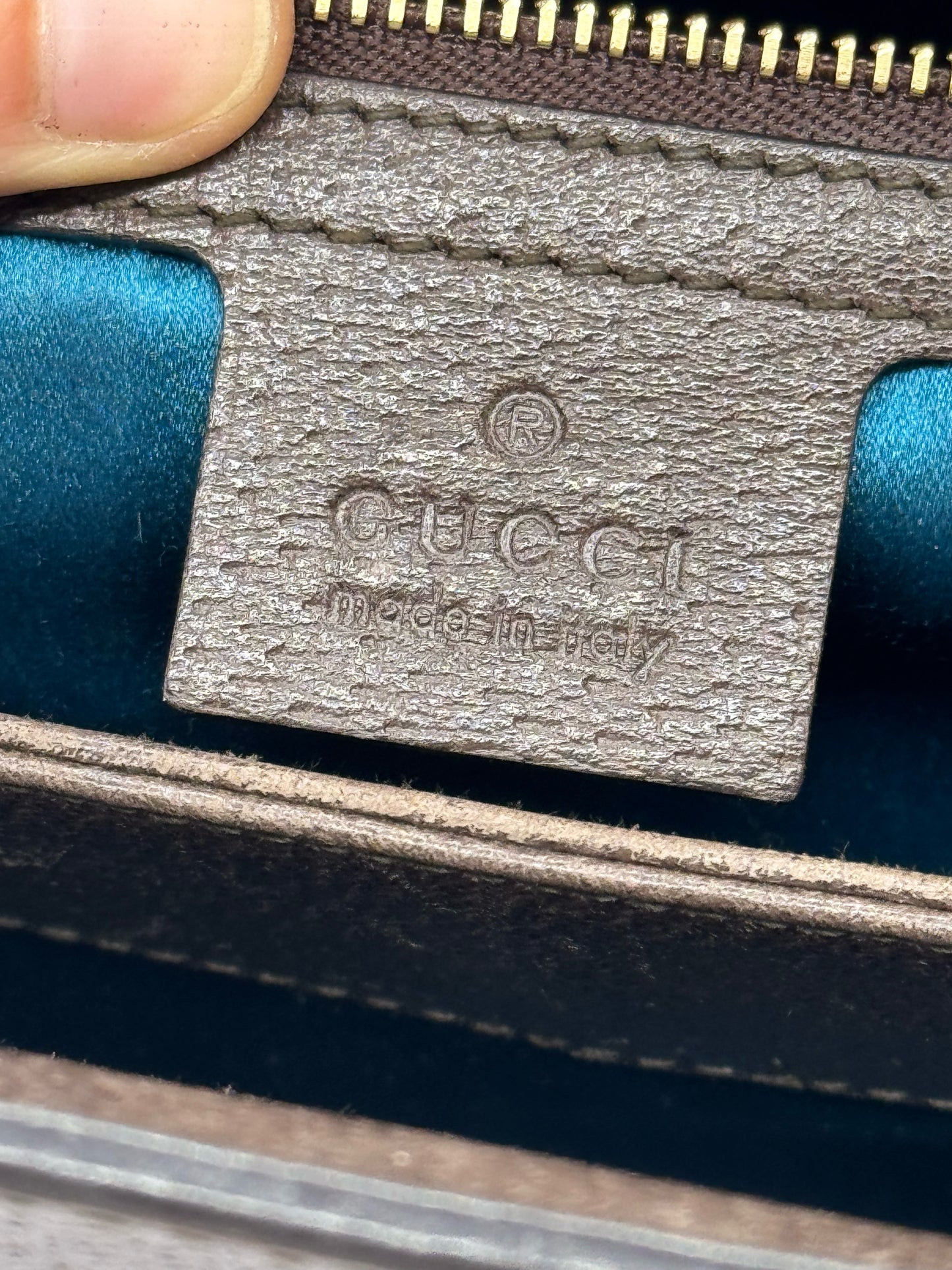 Dettaglio interno della borsa Borse Vintage Gucci Ophidia con etichetta in pelle e fodera in raso color petrolio