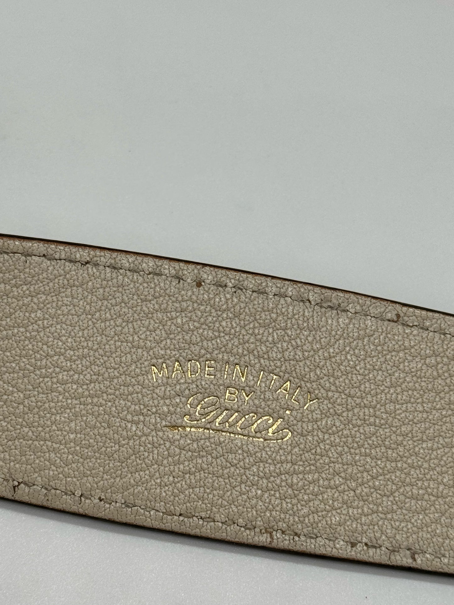 Dettaglio del logo Made in Italy by Gucci impresso in oro su pelle martellata avorio di una borsa Borse Vintage
