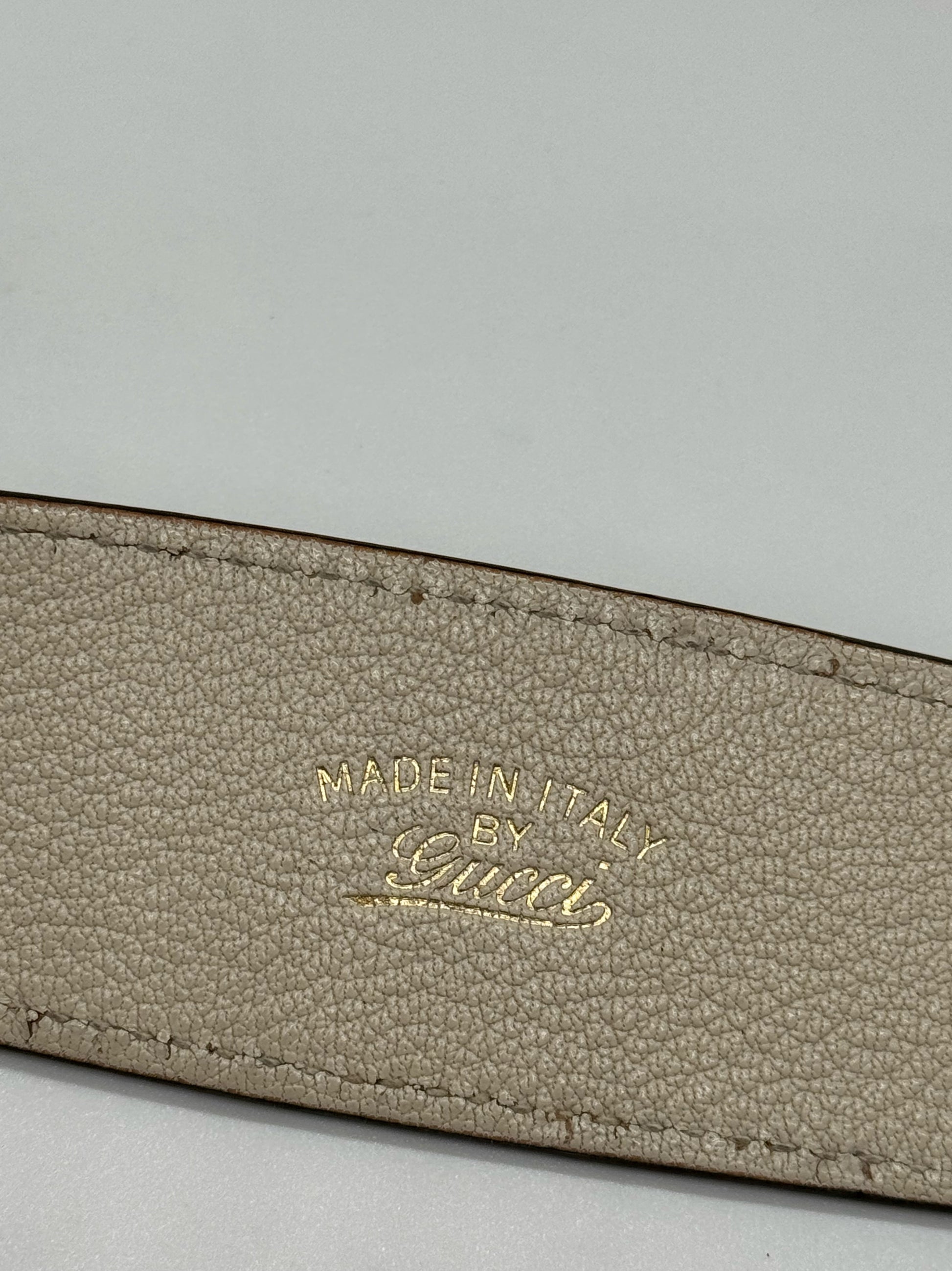 Dettaglio del logo Made in Italy by Gucci impresso in oro su pelle martellata avorio di una borsa Borse Vintage