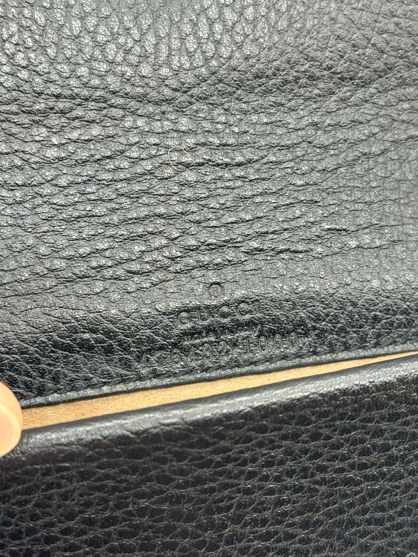 Dettaglio del logo Gucci impresso su pelle nera martellata della borsa Dionysus proposta da Borse Vintage
