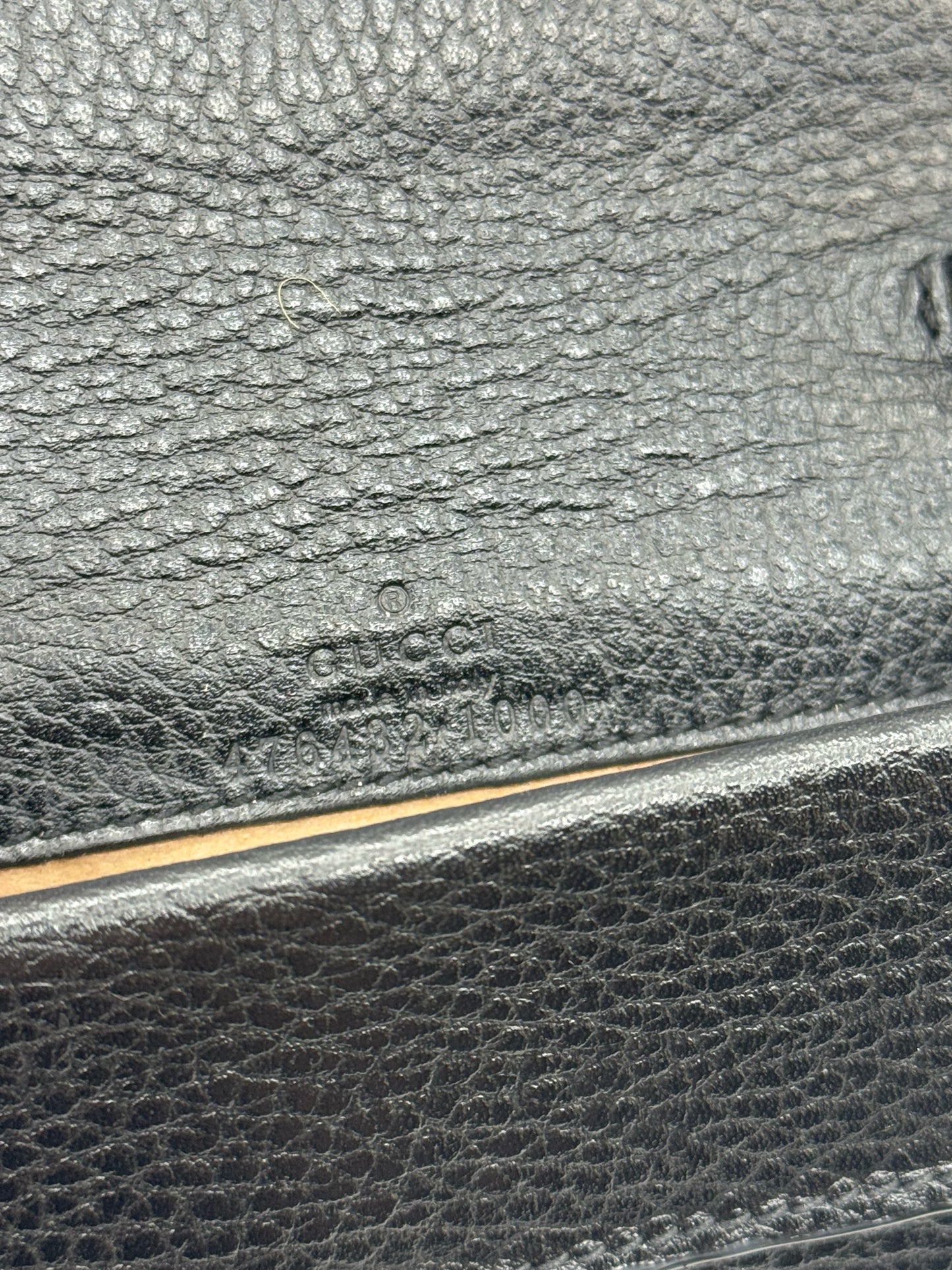 Dettaglio del logo Gucci impresso su pelle nera martellata della borsa Borse Vintage Dionysus