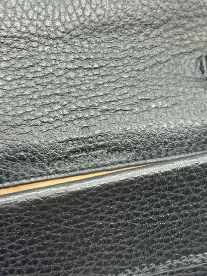 Dettaglio del logo Gucci impresso su pelle nera martellata della borsa Borse Vintage Dionysus
