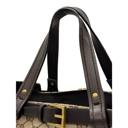 Dettaglio dei manici in pelle marrone e fibbia dorata della borsa tote Gucci in tela GG Supreme di Borse Vintage
