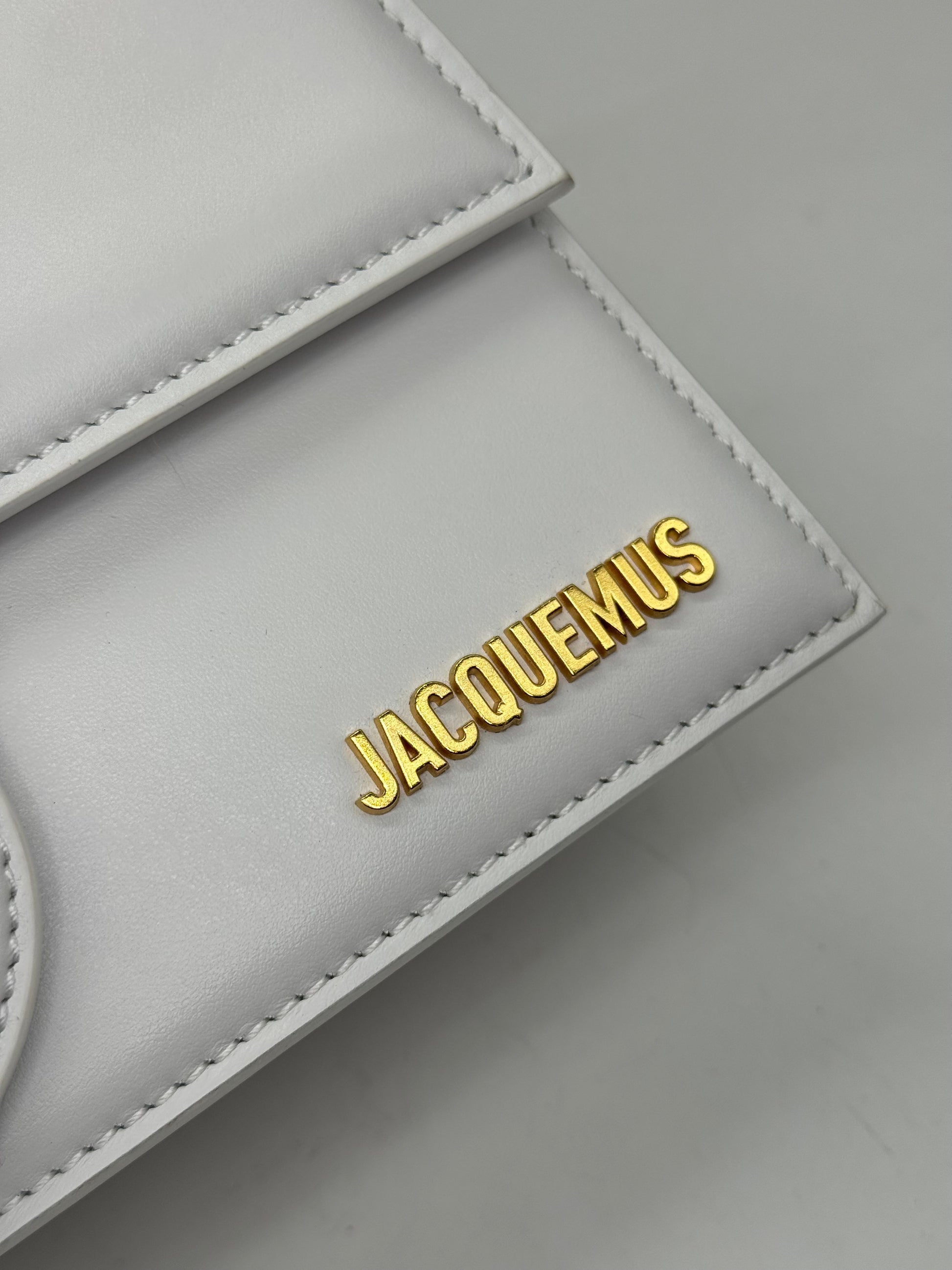 Dettaglio della borsa Borse Vintage Jacquemus in pelle grigio chiaro con logo metallico dorato in rilievo