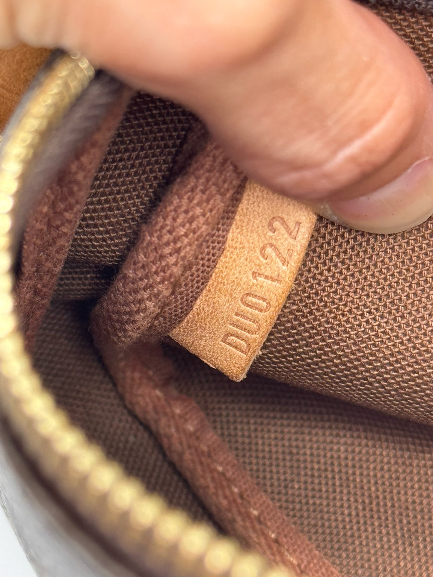 Dettaglio del codice di autenticita impresso su etichetta in pelle interna della pochette Borse Vintage Louis Vuitton