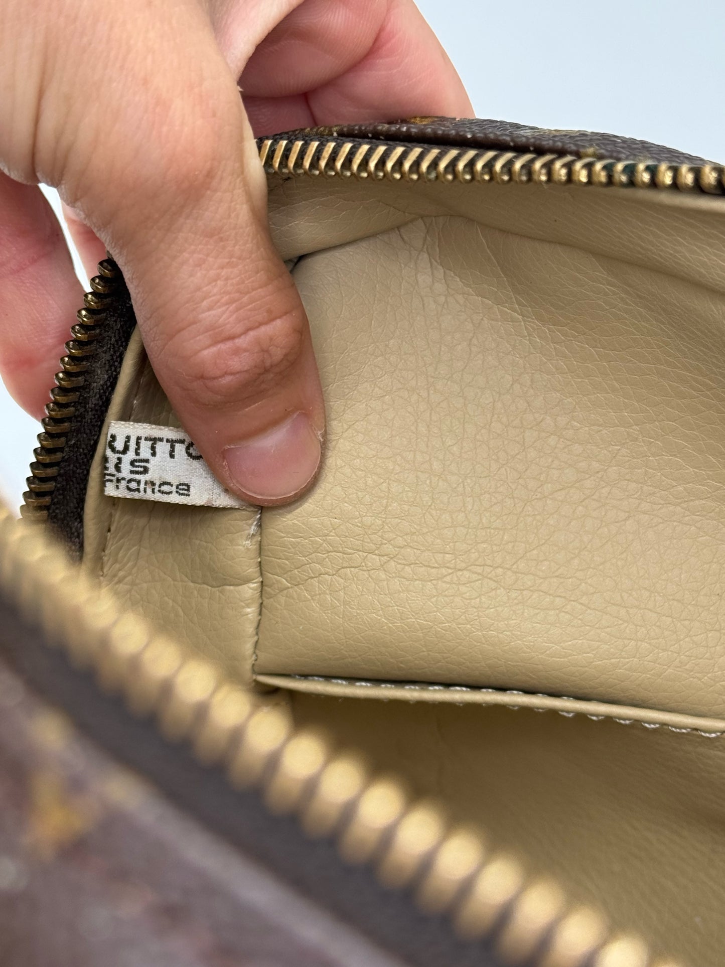 Dettaglio interno della pochette Borse Vintage Louis Vuitton con etichetta originale e fodera in pelle color crema