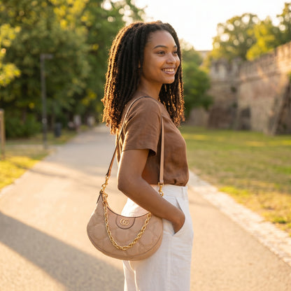 Modella indossa mini borsa a spalla Borse Vintage Gucci GG Matelassé beige in pelle con catena dorata in un parco