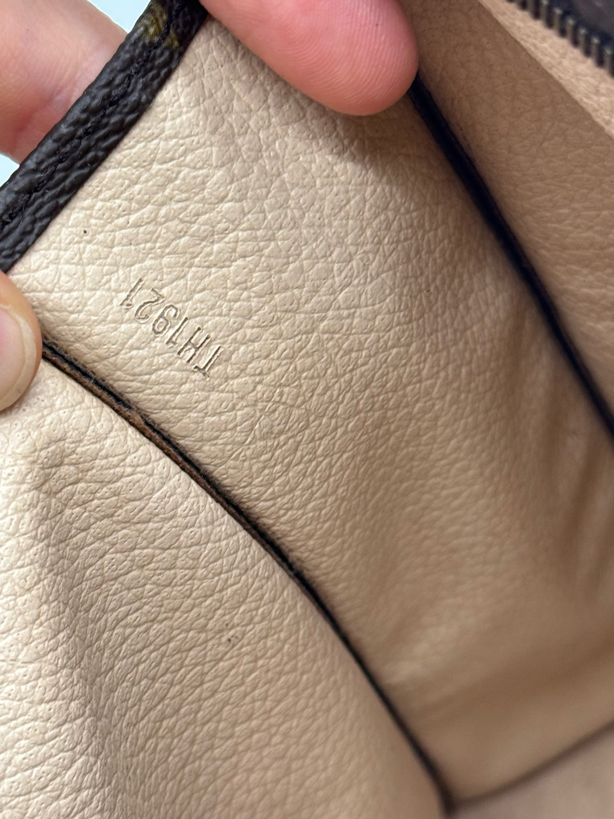Dettaglio interno della pochette Borse Vintage con codice di autenticità impresso sulla pelle chiara