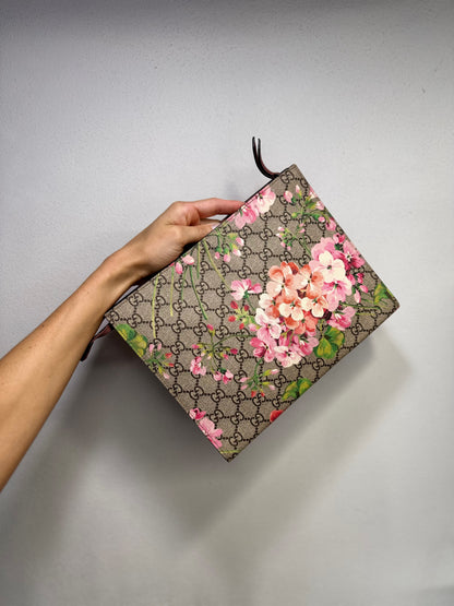 Pochette Borse Vintage Gucci in tela GG Supreme con stampa floreale rosa e dettagli in pelle bordeaux tenuta in mano