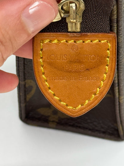 Dettaglio dell'etichetta in pelle Borse Vintage su pochette Louis Vuitton in tela Monogram con cuciture a contrasto