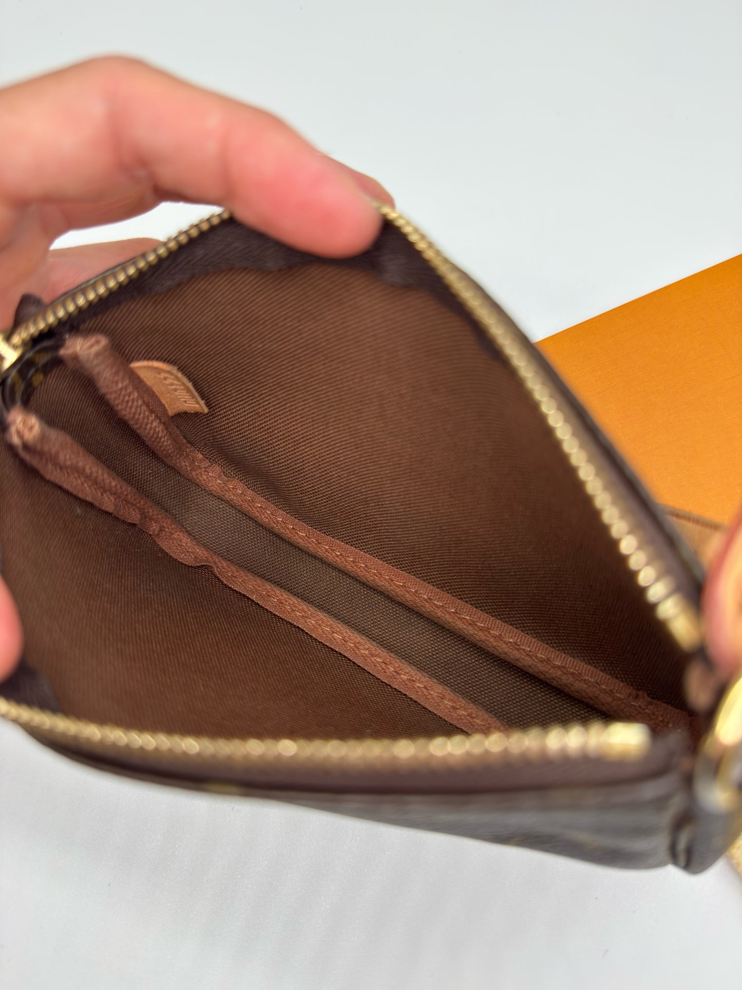 Interno della pochette Borse Vintage Louis Vuitton in tela marrone con fodera in tessuto e chiusura a zip dorata