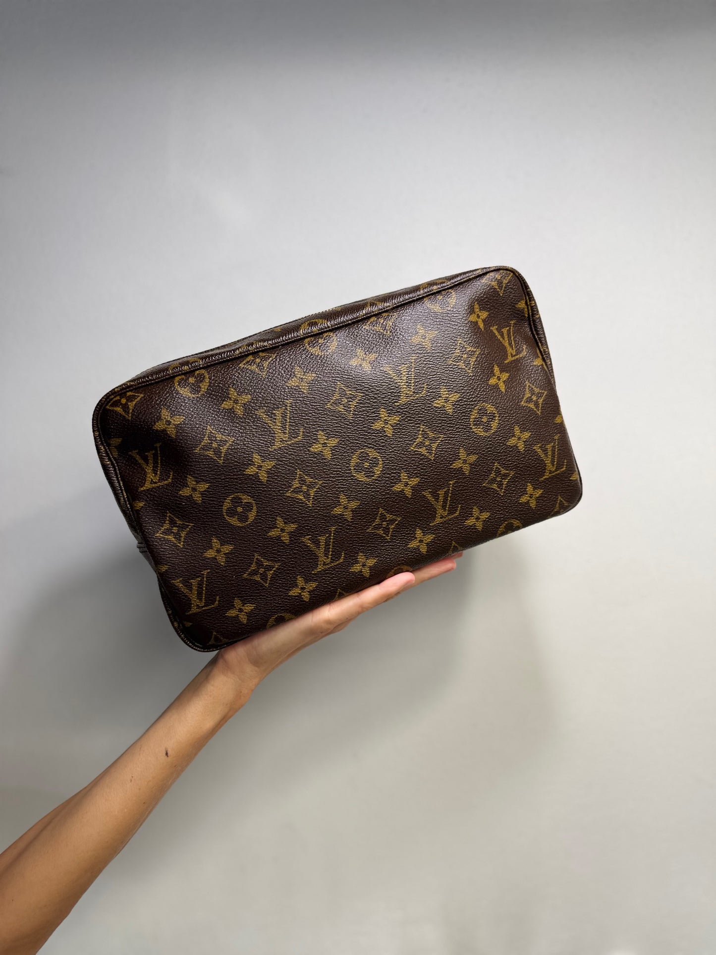 Pochette Louis Vuitton vintage in tela Monogram marrone tenuta in mano, proposta da Borse Vintage