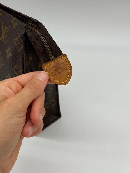 Dettaglio della chiusura a zip con linguetta in pelle Borse Vintage su pochette Louis Vuitton in tela Monogram
