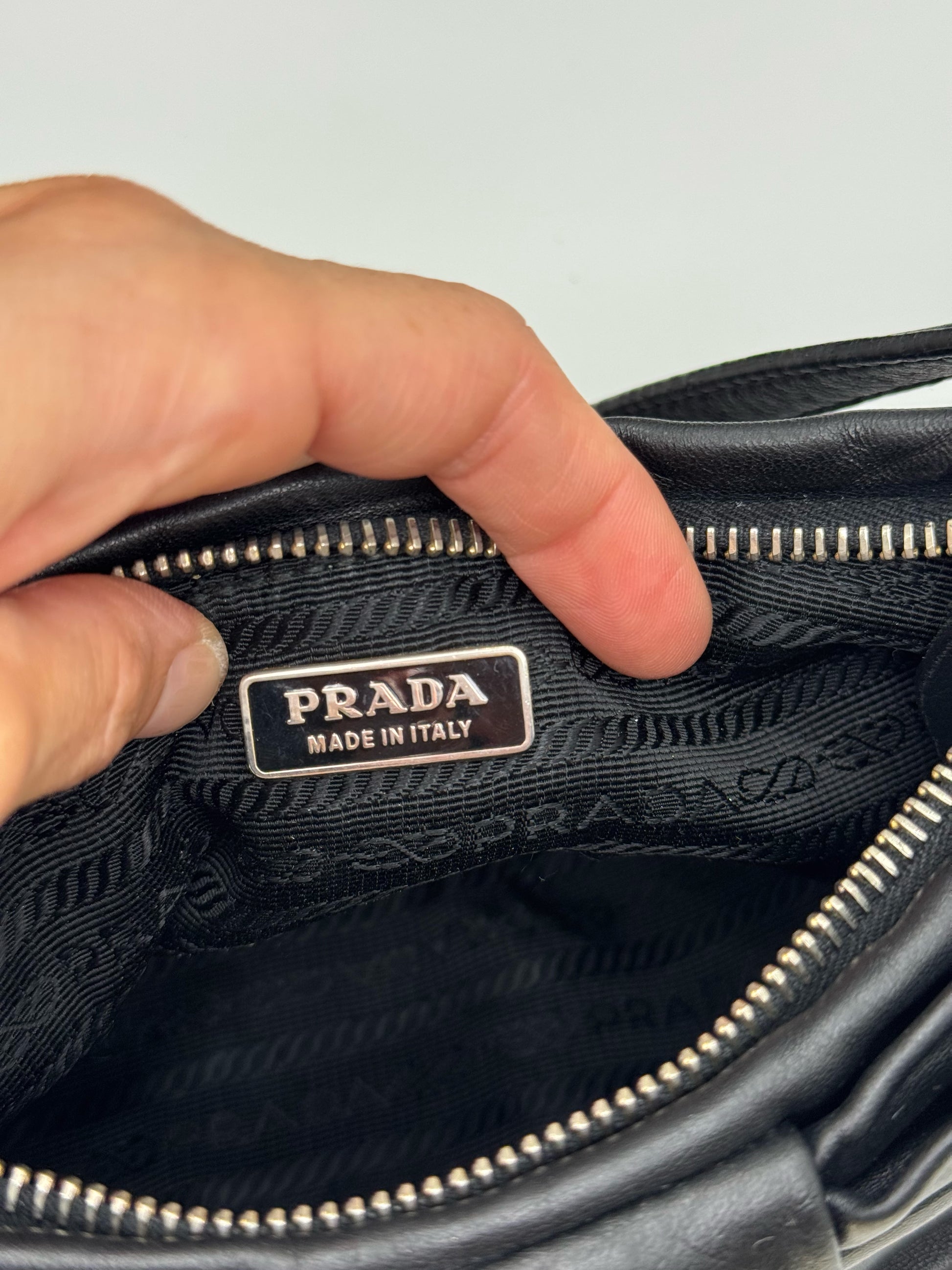 Dettaglio interno della borsa a spalla Borse Vintage Prada in pelle nera con targhetta metallica e fodera logata