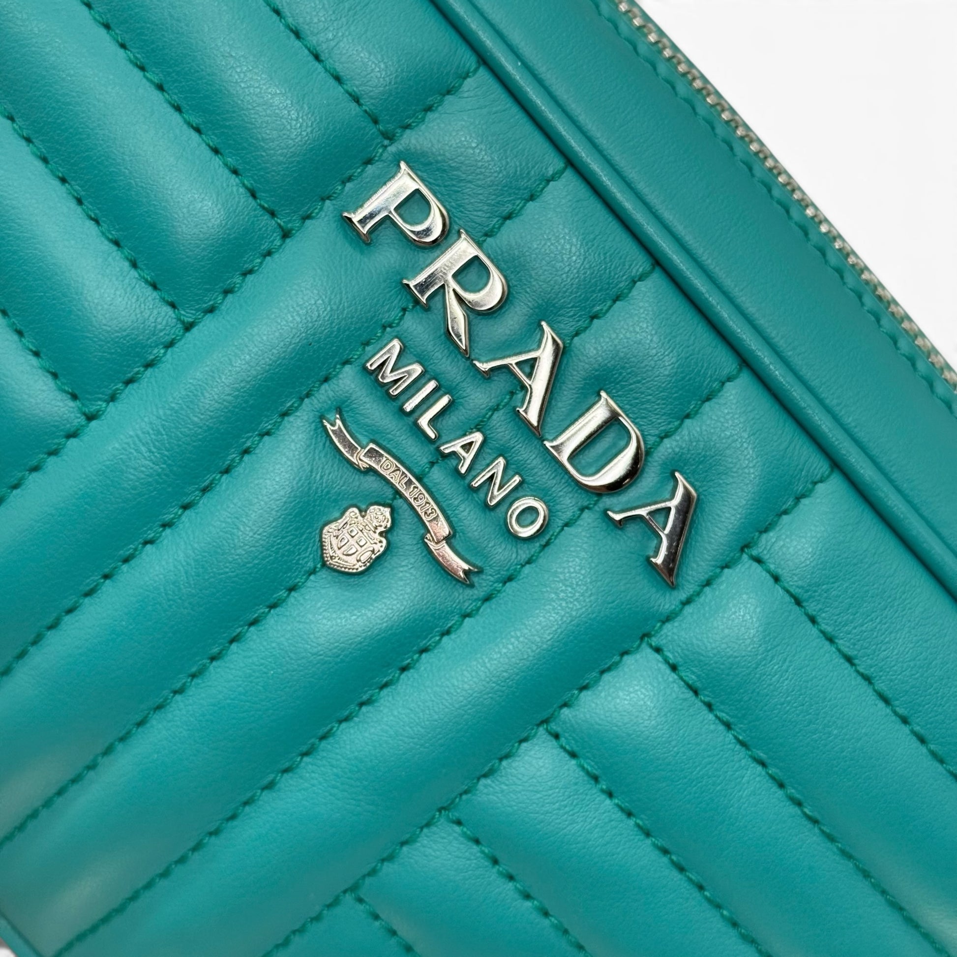 Dettaglio del logo metallico su borsa a tracolla Borse Vintage Prada in pelle trapuntata verde smeraldo