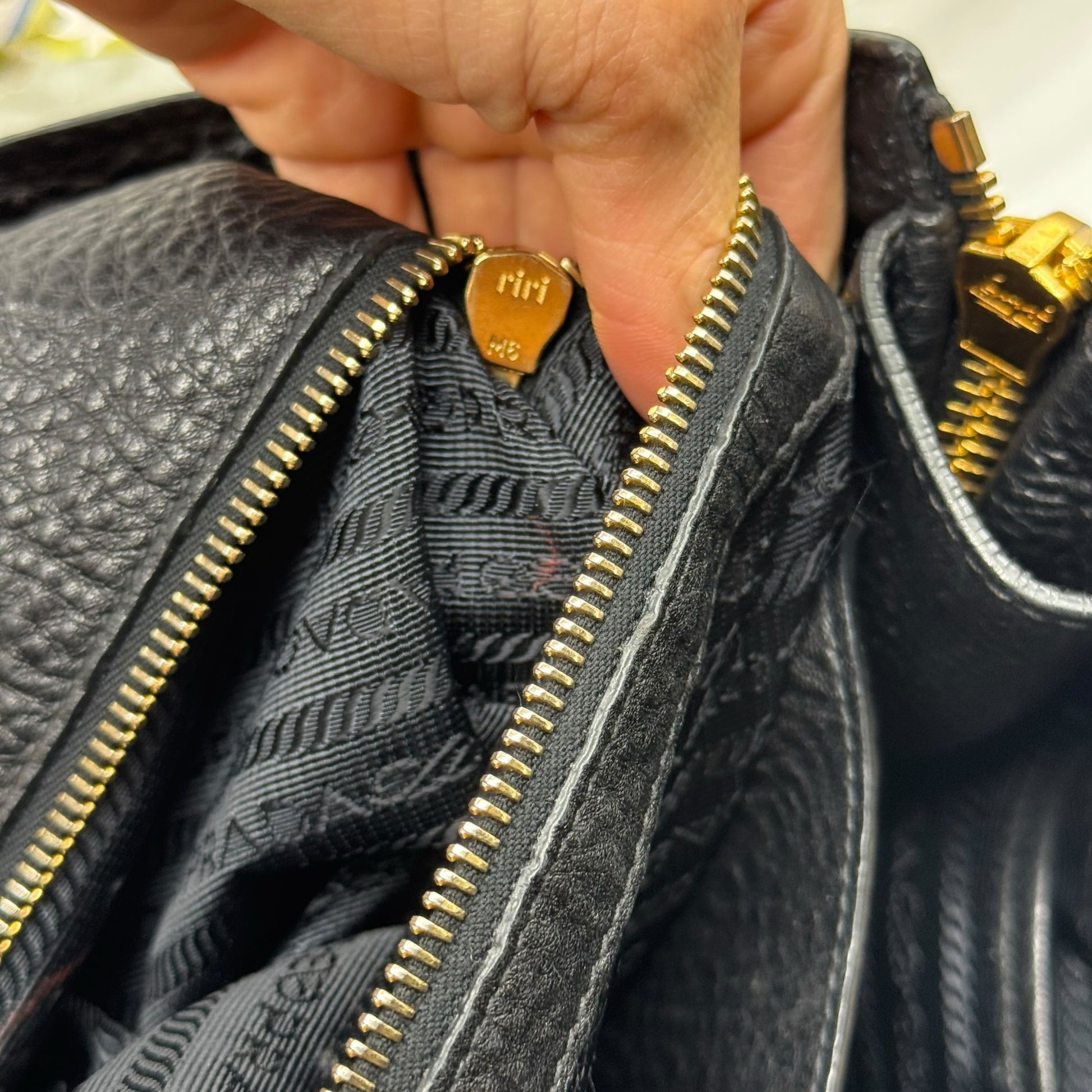 Dettaglio della chiusura con zip dorata e interno foderato logato della borsa tote Borse Vintage Prada in pelle nera