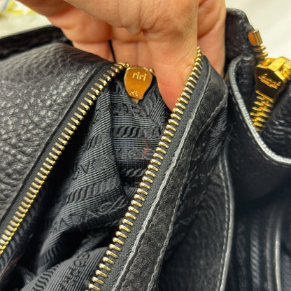 Dettaglio della chiusura con zip dorata e interno foderato logato della borsa tote Borse Vintage Prada in pelle nera
