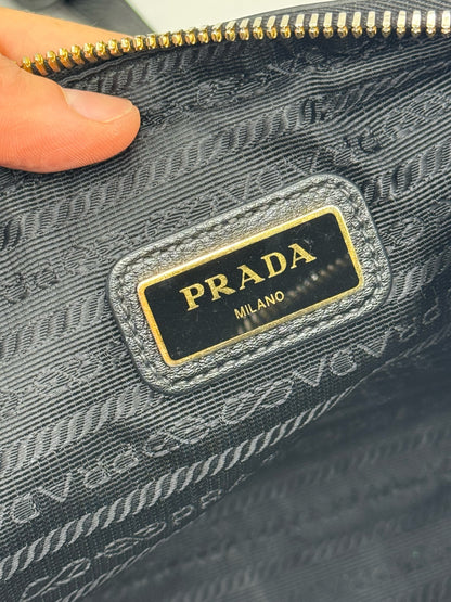 Dettaglio interno della borsa Borse Vintage Prada con etichetta logo in metallo dorato su fodera logata nera