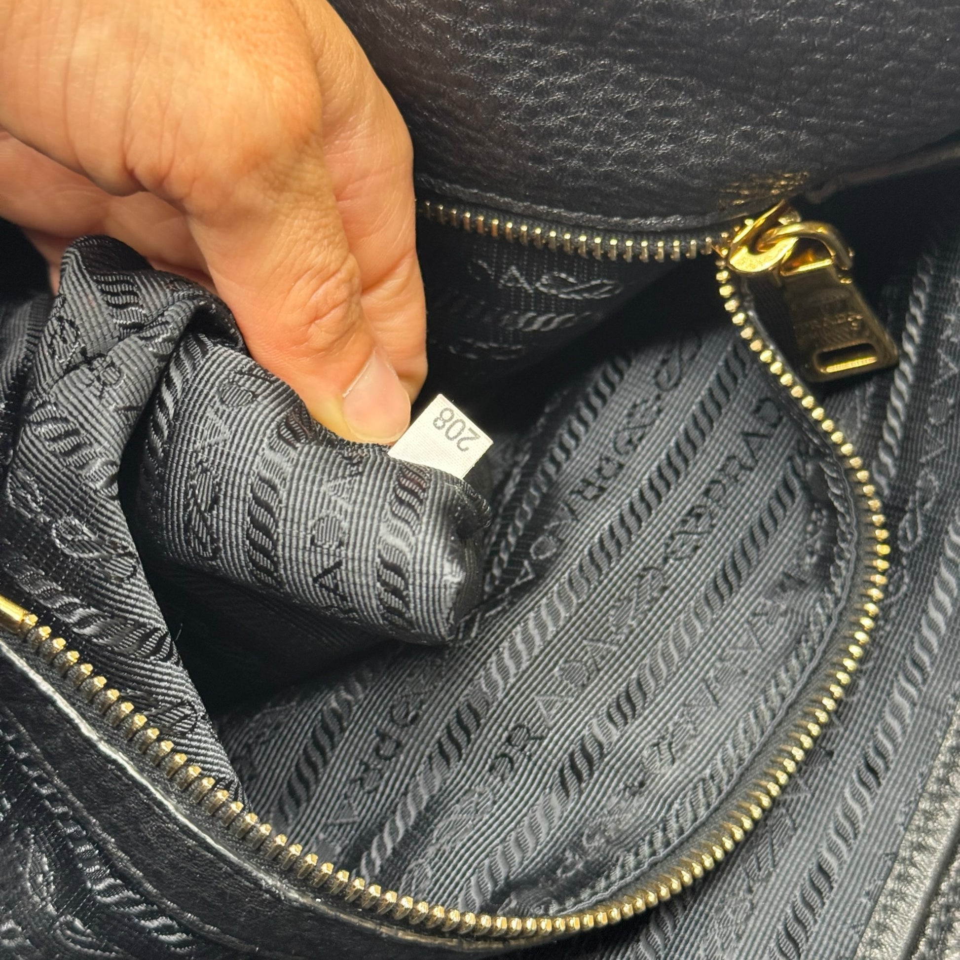 Dettaglio interno della borsa tote Borse Vintage Prada in pelle nera con fodera logata e etichetta di autenticità