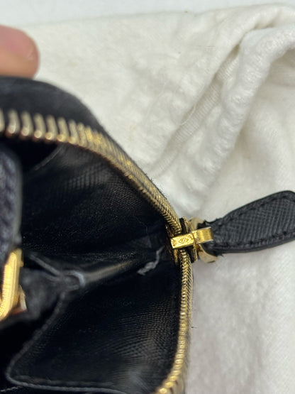 Dettaglio della cerniera dorata e interno in pelle nera di un portafoglio Prada autentico da Borse Vintage