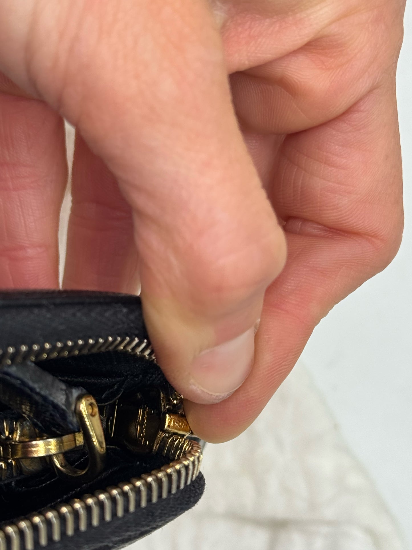 Dettaglio della cerniera dorata di un portafoglio Borse Vintage Prada in pelle Saffiano nera