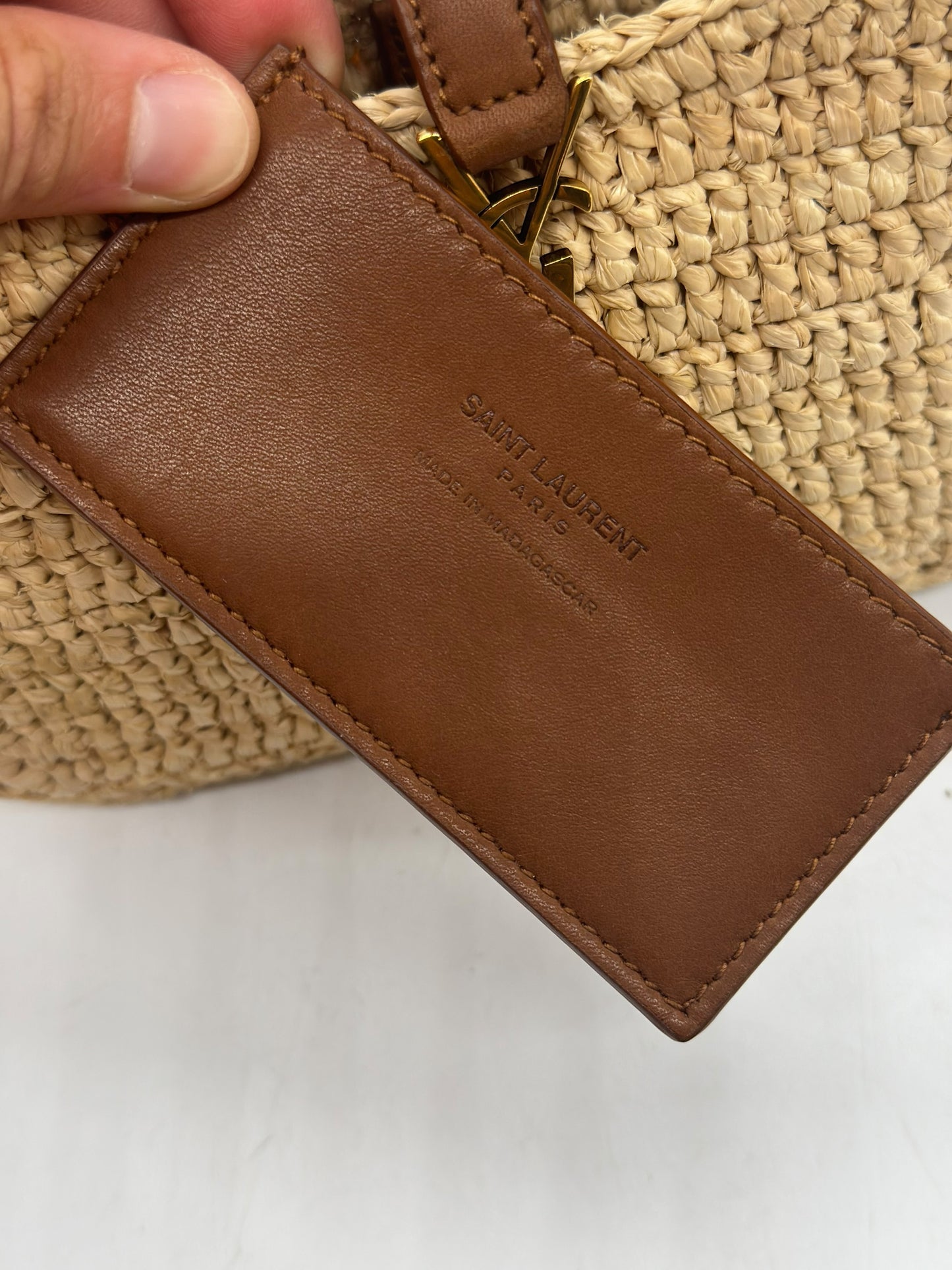 Dettaglio dell'etichetta in pelle marrone Borse Vintage su borsa a spalla Saint Laurent in rafia intrecciata
