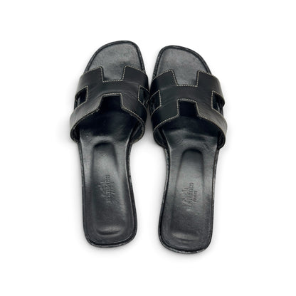 Sandali bassi Borse Vintage in pelle nera con iconico design a H e cuciture a contrasto, vista dall'alto.