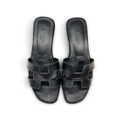 Sandali bassi Borse Vintage in pelle nera con iconico design a H e cuciture a contrasto, vista dall'alto.
