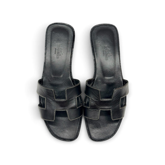 Sandali bassi Borse Vintage in pelle nera con iconico design a H e cuciture a contrasto, vista dall'alto.