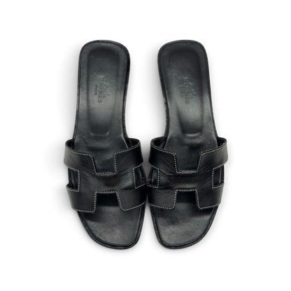Sandali flat Borse Vintage in pelle nera con iconico design a H e cuciture a contrasto, vista dall'alto.