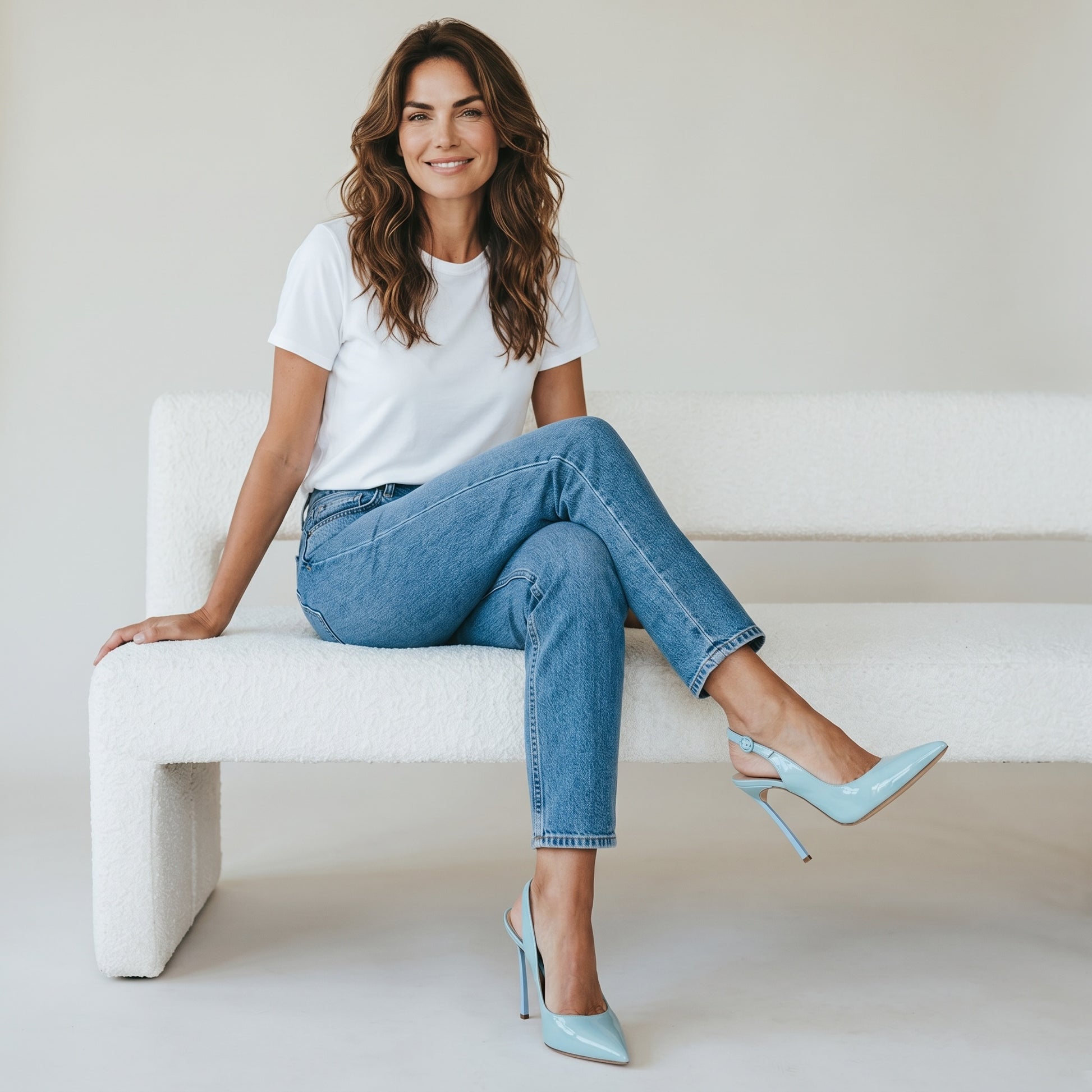 Modella seduta su divano bianco indossa décolleté slingback azzurre in vernice Borse Vintage con tacco a spillo