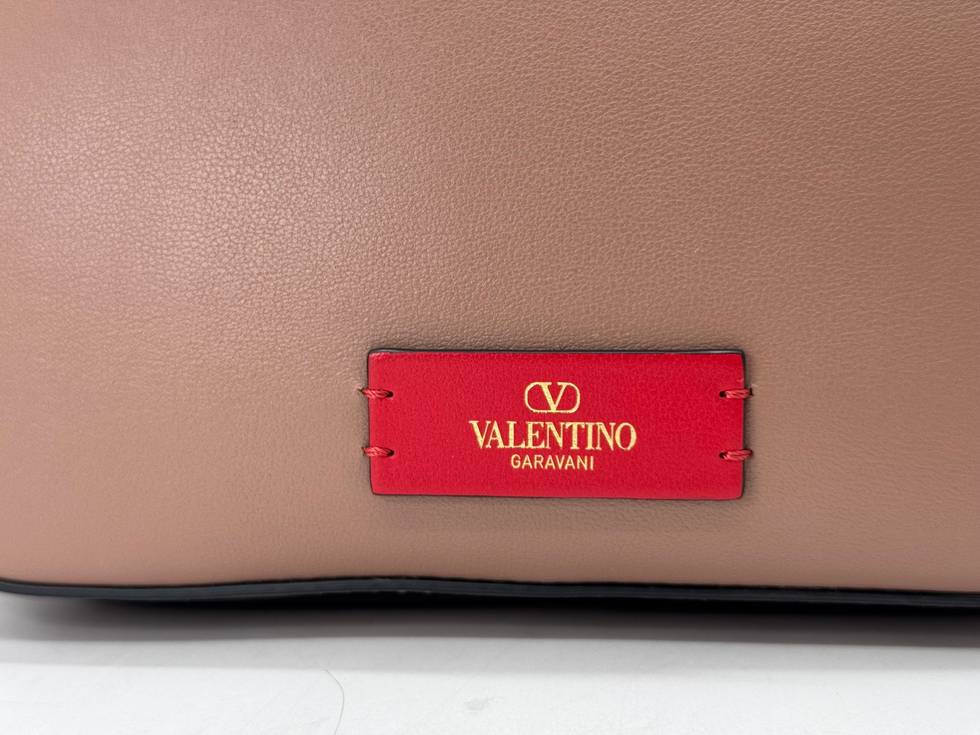 Dettaglio borsa a tracolla Borse Vintage Valentino Garavani in pelle nude con etichetta rossa e logo dorato