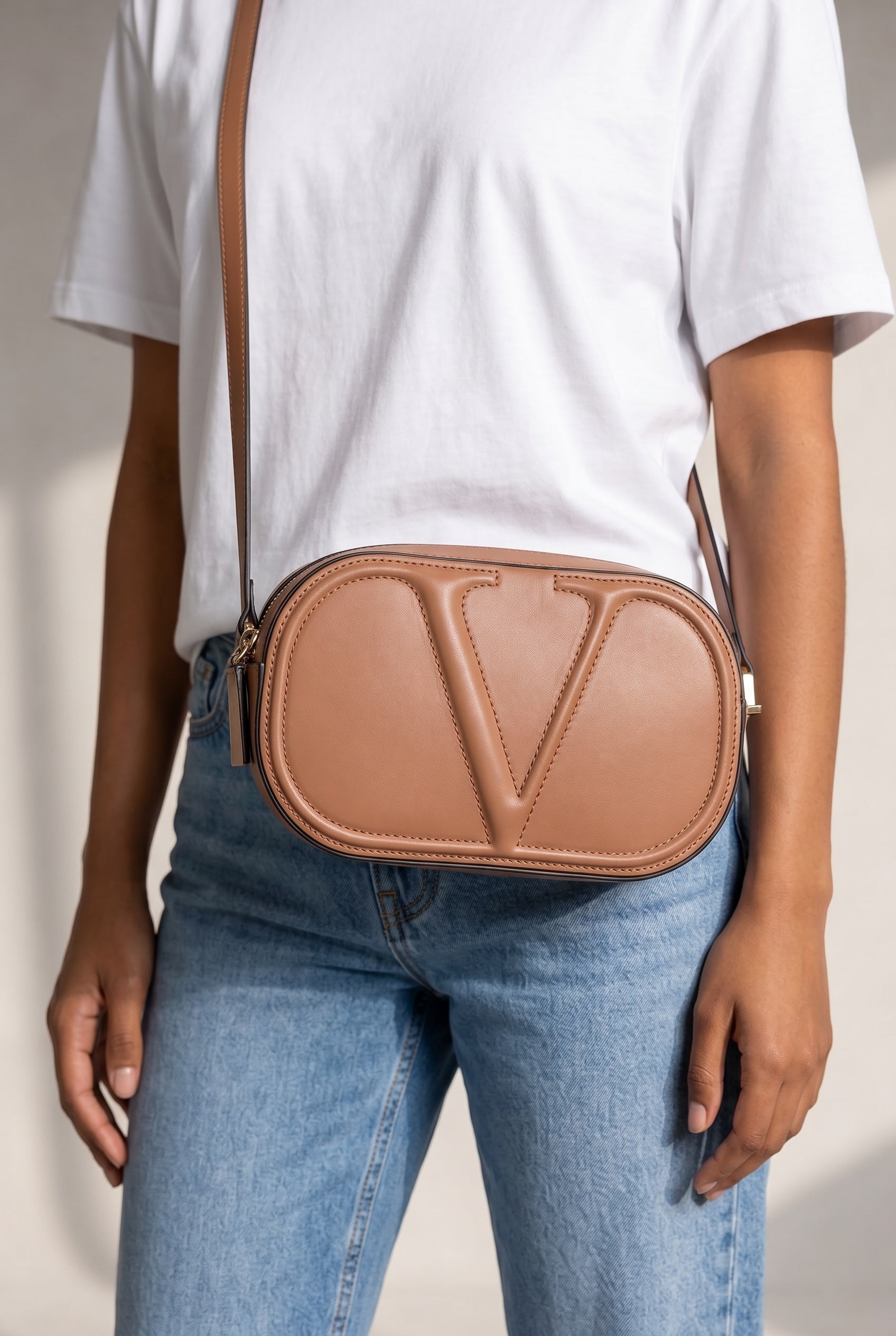 Borsa a tracolla Borse Vintage Valentino Garavani ovale in pelle color nude con logo V in rilievo indossata a spalla