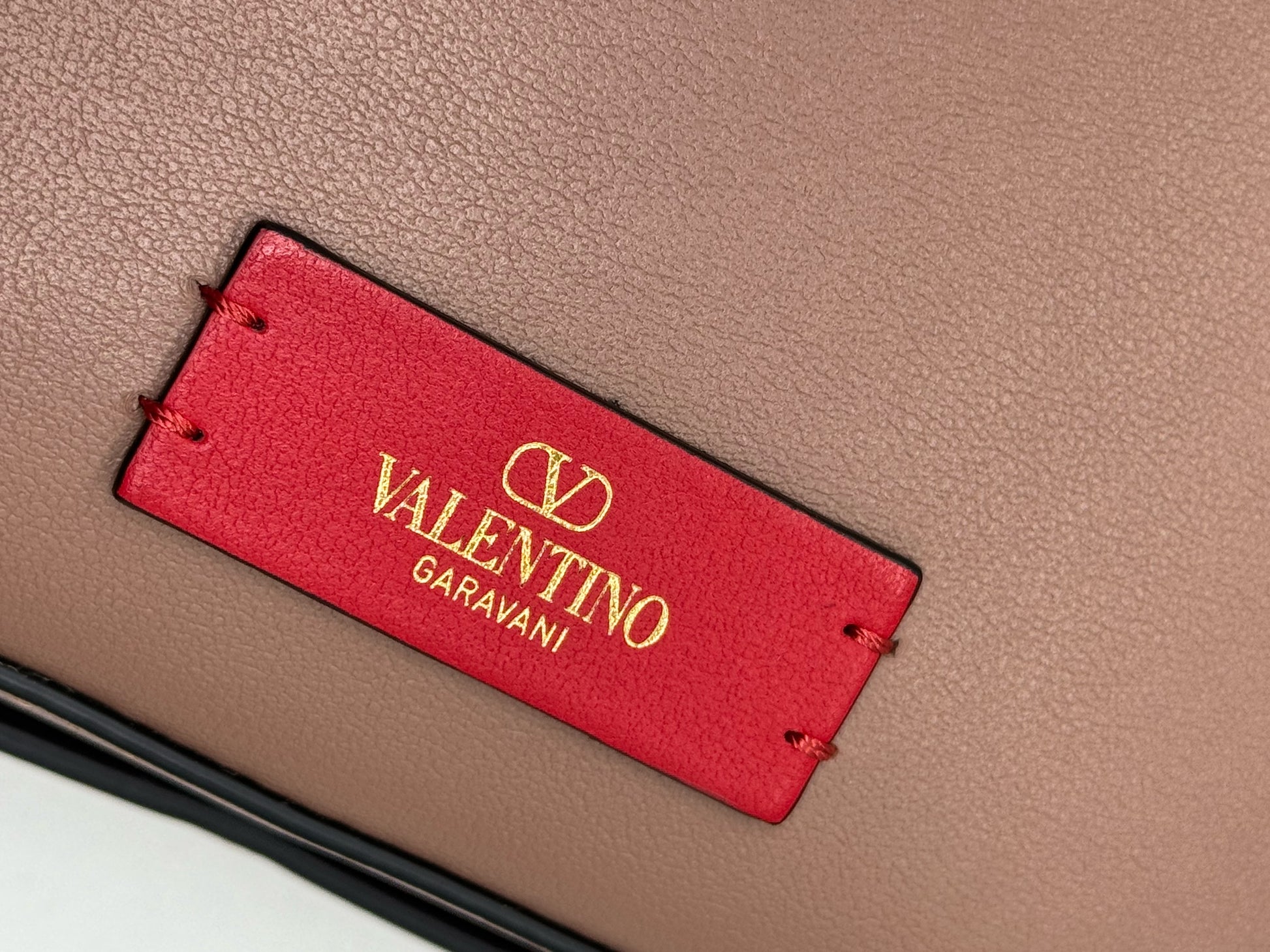 Dettaglio etichetta rossa con logo dorato Valentino Garavani su borsa in pelle nude Borse Vintage